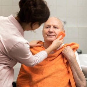 Personal hygiene – home caregiver with senior man in bathroom Personal hygiene – home caregiver with senior man in bathroom